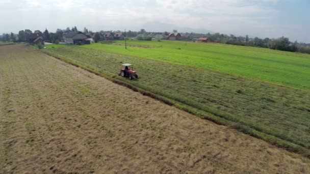 Tractor en un campo de hierba — Vídeos de Stock