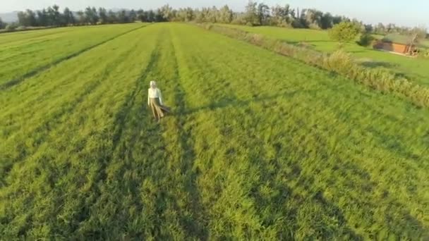 Yaşlı kadın bir çim sahada ayakta — Stok video