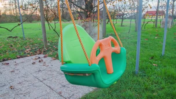 Empty plastic child swing swinging — Stock Video