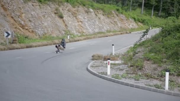 Patinador em uma estrada de montanha sinuosa — Vídeo de Stock
