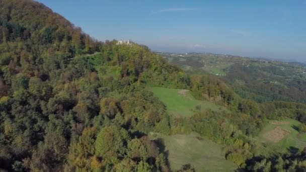 Volando por encima del bosque bajo la montaña — Vídeos de Stock