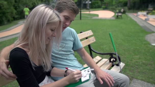 Pontos de marcação de casal no mini campo de golfe — Vídeo de Stock
