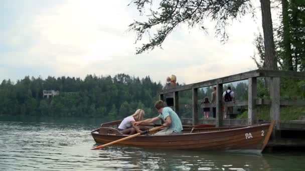 Couple flottant dans un bateau sur le lac — Video