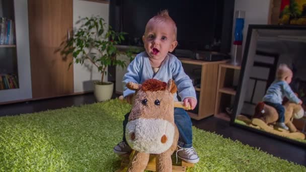 Kleines Kind reitet Plüschpferd — Stockvideo