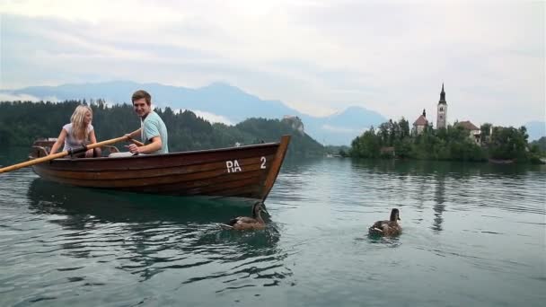 Couple flottant dans un bateau sur le lac — Video