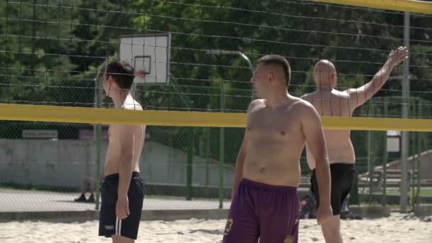 Trois hommes se préparent à jouer au valleyball. — Video