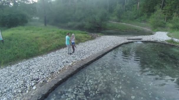 Garçon baiser fille près d'un petit lac 