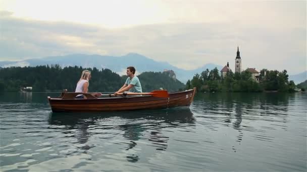 Пара, плывущая на лодке по озеру — стоковое видео