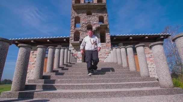 Un homme descend les escaliers devant l'église. — Video