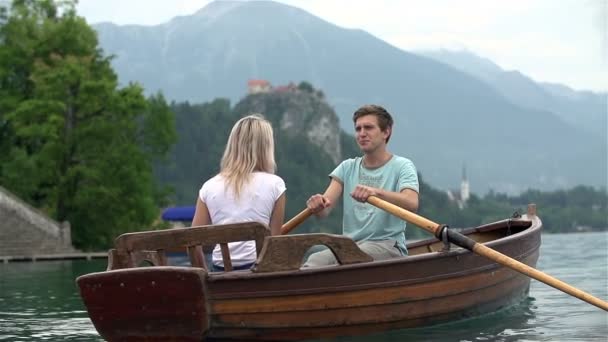 Couple flottant dans un bateau sur le lac — Video