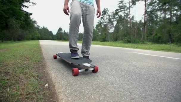 Homme monte une planche à roulettes sur la route — Video