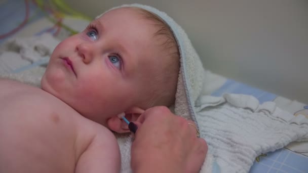 Moeder is het reinigen van de oren van haar baby — Stockvideo