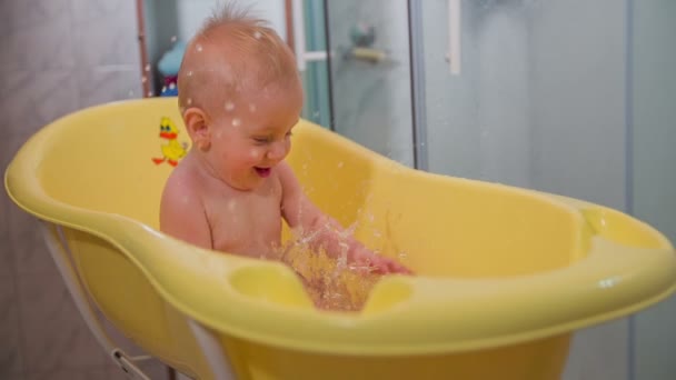 Kleiner Junge spielt in der gelben Badewanne — Stockvideo