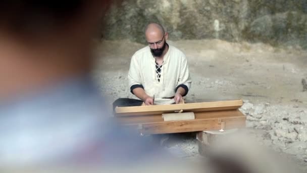 Турист спостерігає, як людина грає на історичному інструменті — стокове відео