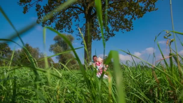 Jeune famille heureuse sous l'arbre 