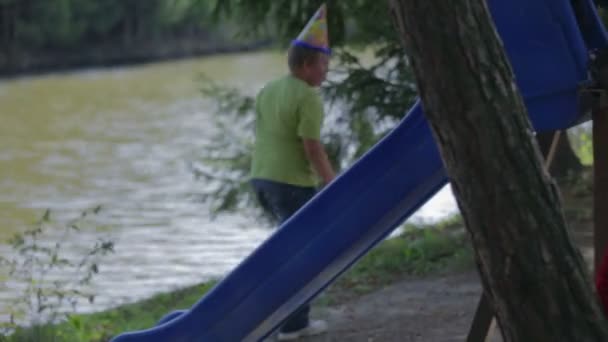 Kinder rutschen auf einer Außenrutsche — Stockvideo