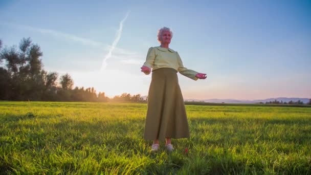 Abuela de pie en el medio de césped verde — Vídeos de Stock