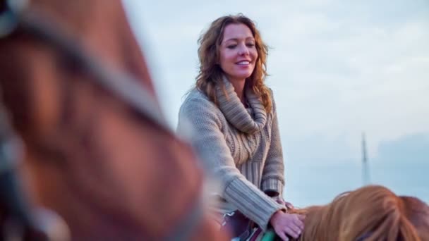 Усміхнена жінка кидає коня на спину — стокове відео