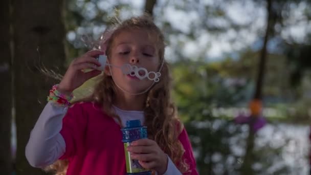 Дівчина дме бульбашки на вечірці дня народження — стокове відео
