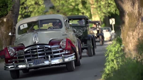 Carros clássicos dirigindo em uma estrada do país — Vídeo de Stock