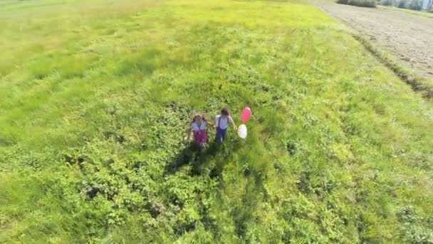 Two kids with balloons running to the camera. — Stock Video