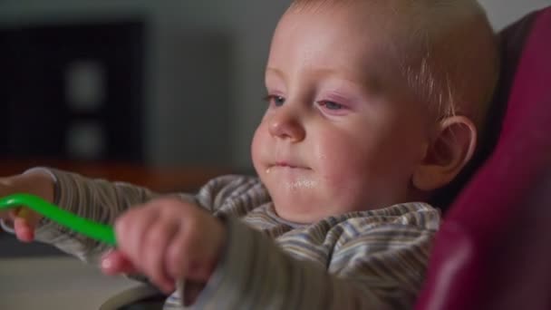 Маленький хлопчик з ложкою в руках — стокове відео