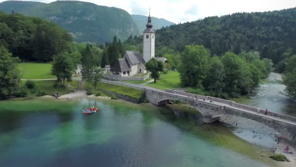 Vliegen over de rivier met brug en kerk — Stockvideo
