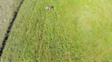 Ellerini tutarak ve bir sahada çalışan çocuklar