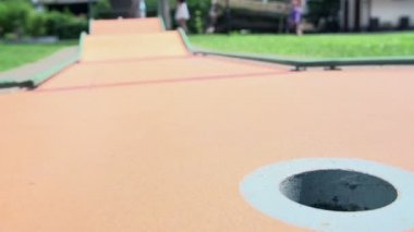 Top pas delik mini golf sahası üzerinde inişli çıkışlı.