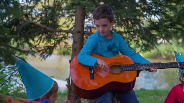 Мальчик играет на гитаре — стоковое видео
