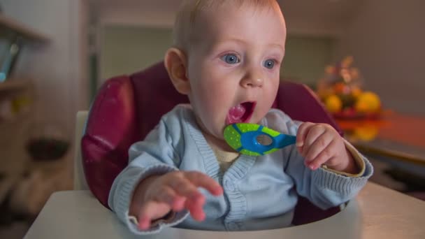 Маленька дитина кусає гумову іграшку — стокове відео