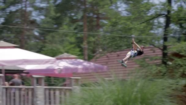 Young small man going fast on zip-line — Stock Video