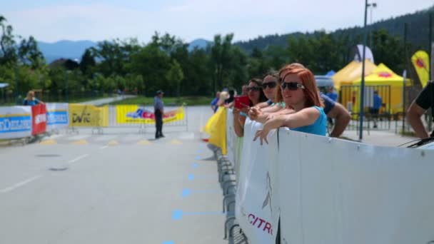 People at fence cheering for competitors — Stock Video