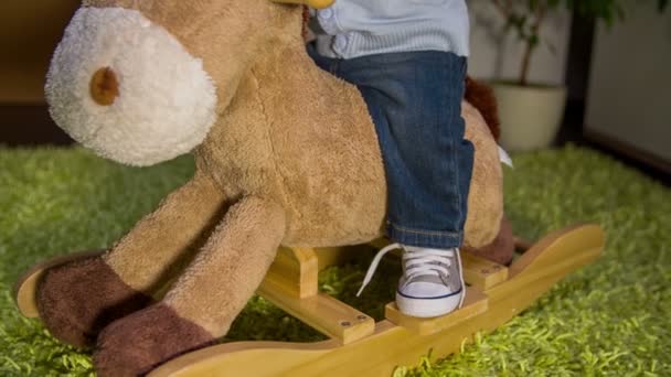 Плюшевый скачущий конь, на котором ездит симпатичный ребенок — стоковое видео
