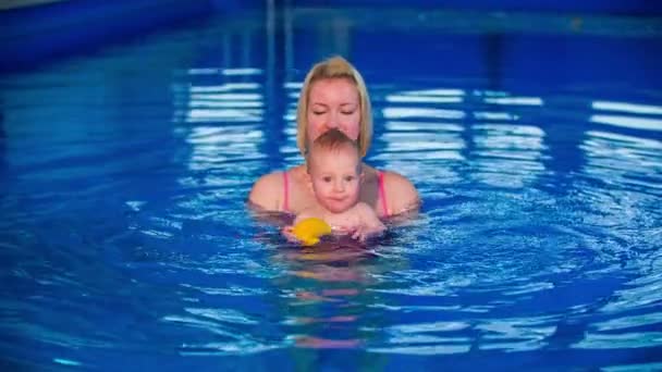 Madre con niño pequeño en la piscina — Vídeo de stock