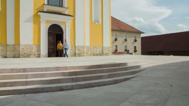 Couple walks out from the historic church — Stock Video