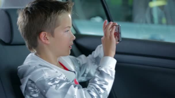 Lindo niño jugando con el teléfono inteligente — Vídeo de stock