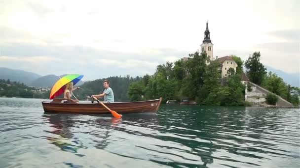 Couple flottant dans un bateau sur le lac — Video