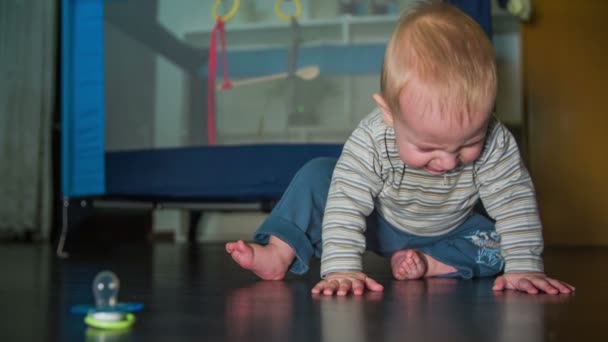 Child sitting on the floor with pacifier in front — Stock Video