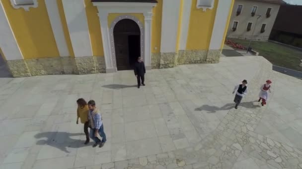 Paar zegt afscheid aan de priester in de buurt van kerk — Stockvideo