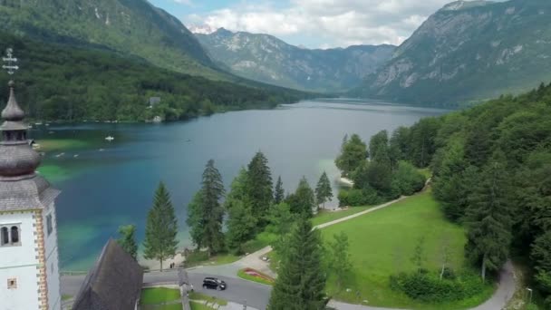 Lago entre montañas e iglesia — Vídeo de stock