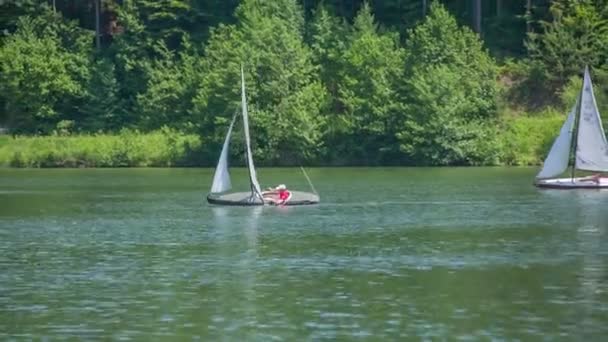 Twee zeilboten zijn zeilen op een meer — Stockvideo