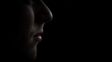 Genç adam sigara içiyor.