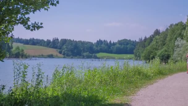 People are running around the lake — Stock Video