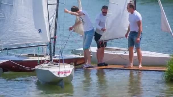 Люди привязывают свои лодки к бую и поднимаются — стоковое видео