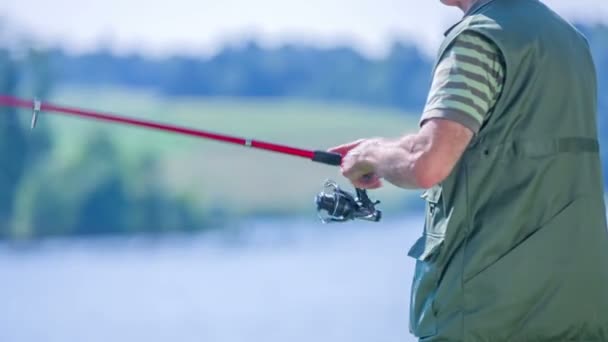 Рибалка розмотує свій рибальський стрижень — стокове відео