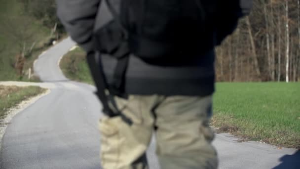 Wandelaar wandelingen op de weg en stopt om te bekijken — Stockvideo