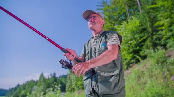 Pescador está desenrollando su caña de pescar — Vídeos de Stock