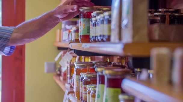 A man is taking off the shelf a jar with honey — Stock Video