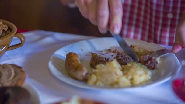 Homem está cortando a carne em seu prato em um restaurante — Vídeo de Stock